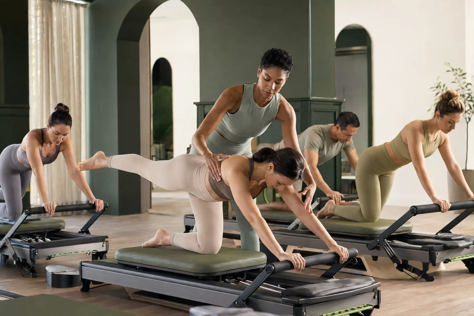A Pilates instructor coaching a reformer class